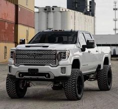 a white truck is parked in front of some shipping containers