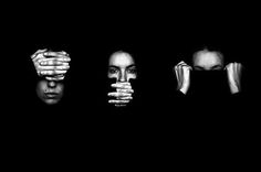 four people with hands covering their faces in black and white