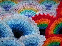 a crocheted blanket is laying on top of the floor with different colors and shapes