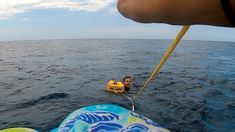 a man is in the water on a small boat with a life preserver attached to it