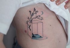 a woman's stomach with a small tattoo on it that has a tree in a vase