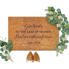 a pair of shoes sitting next to a door mat with the words give thanks to the god of heaven