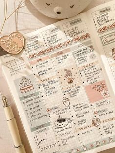 an open planner sitting on top of a table next to a cup of coffee and a pen