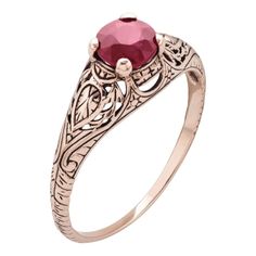 an antique style ring with a red stone in the center