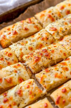 several slices of pizza sitting on top of a baking sheet with cheese and seasoning