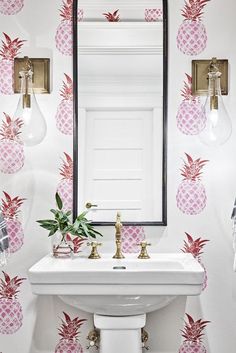 a white sink sitting under a mirror next to a wall mounted faucet in a bathroom