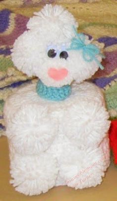 a white stuffed animal sitting on top of a bed next to a red heart shaped pillow