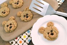 cookies with chocolate chips are on a plate next to a spatula and utensil