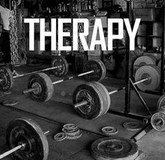 there is a gym with barbells and weight plates in the foreground that says therapy