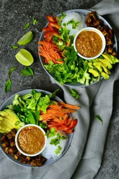 two plates filled with different types of food on top of a cloth covered tablecloth