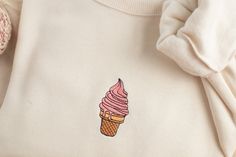 Embroidered Ice Cream Sweatshirt Stay cozy and fun with our uniquely embroidered sweatshirt! Made with love and THOUSANDS of threads! -Unisex Size (Please see the size chart for more details that can be found in the photos section)  We recommend comparing your favorite sweatshirt to our size chart to find the best size for you! Unisex Crewneck -50% cotton 50% polyester -Super soft -Pre-shrunk -Unisex -Design size is 3''-4"  Thread: We use the best quality threads for our embroidery designs. Casual Pink Sweatshirt With Machine Embroidery, Cute Cream Cotton Sweatshirt, Casual Embroidered Cream Sweatshirt, Casual Cream Embroidered Sweatshirt, Crewneck Designs, Cream Crewneck, Cream Sweatshirt, Summer Sweatshirt, 자수 디자인