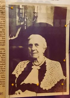 an old black and white photo of a woman in crocheted dress with yellow pins on her collar