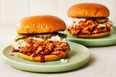 two pulled pork sandwiches on green plates