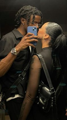 a man and woman taking a selfie in the mirror with their cell phones together