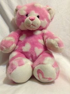 a pink and white teddy bear with hearts on it