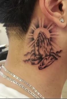 a person with a tattoo on their neck and behind the ear that has a praying hand