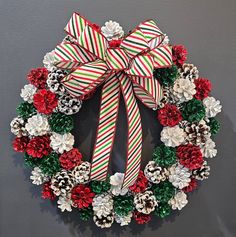 a christmas wreath with pine cones and candy canes