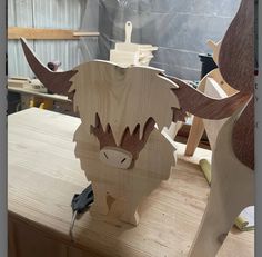 a wooden sculpture of a bull with horns on it's head sitting on a table