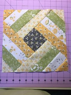 a piece of fabric that has been made into a patchwork quilt on top of a cutting board