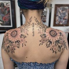 the back of a woman's neck with sunflowers on it