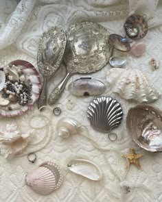 various seashells and silverware on a white tablecloth