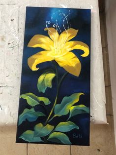 a painting of a yellow flower on a tile floor