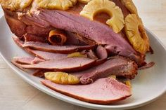 sliced ham and pineapples on a white plate