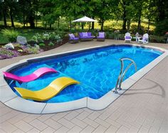 a pool with a slide in the middle of it and some lawn chairs around it