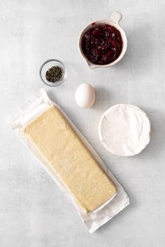 ingredients to make cranberry bread laid out on a white surface with parchment paper