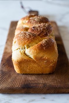 a loaf of bread sitting on top of a wooden cutting board