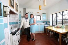 a man and woman are standing in the kitchen