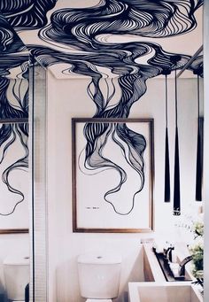 a bathroom with black and white artwork on the ceiling