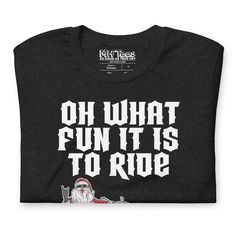 Celebrate Metal Christmas with this Metal Christmas graphic tee featuring Santa Claus Riding a Motorcycle and raising the devil horns. Novelty Heavy Metal Santa Claus on Motorcycle t-shirt with hand horns and the words Oh What Fun It is To Ride. A funny Heavy Metal Santa graphic tee for Rock Metal fan who is feeling festive. A funny Metal Christmas t-shirt featuring Santa on a chopper with hand horns. The perfect Christmas graphic tee for Santa lovers who love riding their motorcycle. This t-shi Funny Holiday T-shirt With Graphic Print, Christmas Novelty T-shirt With Graphic Print, Novelty Christmas T-shirt With Graphic Print, Novelty Christmas Graphic Print T-shirt, Metal Santa Claus, Santa Graphic, Riding A Motorcycle, Devil Horns, Oh What Fun