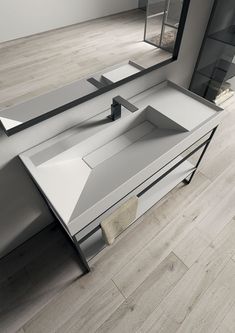 a bathroom sink sitting on top of a wooden floor next to a mirror and counter