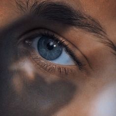 an image of a person's blue eye looking at the camera with only one eye visible