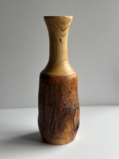 a wooden vase sitting on top of a white table