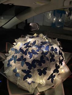 an umbrella with blue butterflies on it sitting in the middle of a car's dashboard