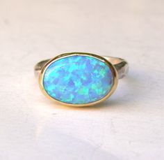 OPAL RING You are looking at a beautiful HAND MADE silver and gold ring with opal stone. The stone are setting in 14k gold bazel It is impressive, powerful and very beautiful ring. Made to order any size.. This ring can be made to order in any size. Please note your desired size in the message to seller area at checkout. size stone is 10mmX14mm width ring: 3mm Come in a gift box. Fallow me on facebook for newest updates. http://www.facebook.com/pages/Orit-Naar-jewelry/174677569247132?sk=wall October Stone, Elf Door, Blue Opal Ring, Solitaire Rings, Ring Opal, For Her, Engagement Rings Opal, Birthday Ring, Oval Ring