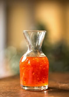 a small glass bottle filled with sauce on top of a wooden table