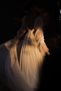 the back of a woman's white dress with long sleeves