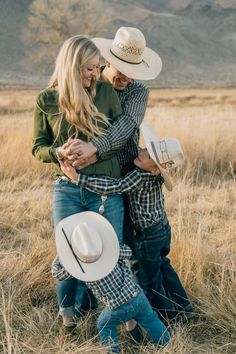 two people hugging each other in the middle of a field