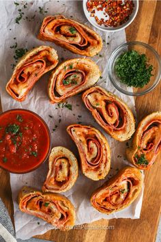 some food is laying out on a wooden board with sauces and condiments