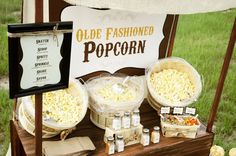 an olde fashioned popcorn stand is set up with various items for sale on the table