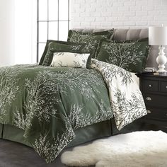 a bed with green and white comforters in a room