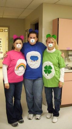 three children with face paint standing next to each other in a hospital room wearing costumes