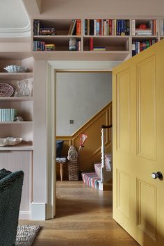 an open door leading to a living room with bookshelves and other items on the shelves