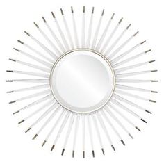 a white sunburst mirror on a wall with pins in the shape of a star