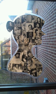 a teddy bear made out of photos in front of a brick building with a window