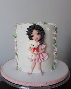 there is a cake with a doll and a teddy bear on it