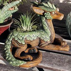 a wooden bench topped with plants and a small planter filled with succulents